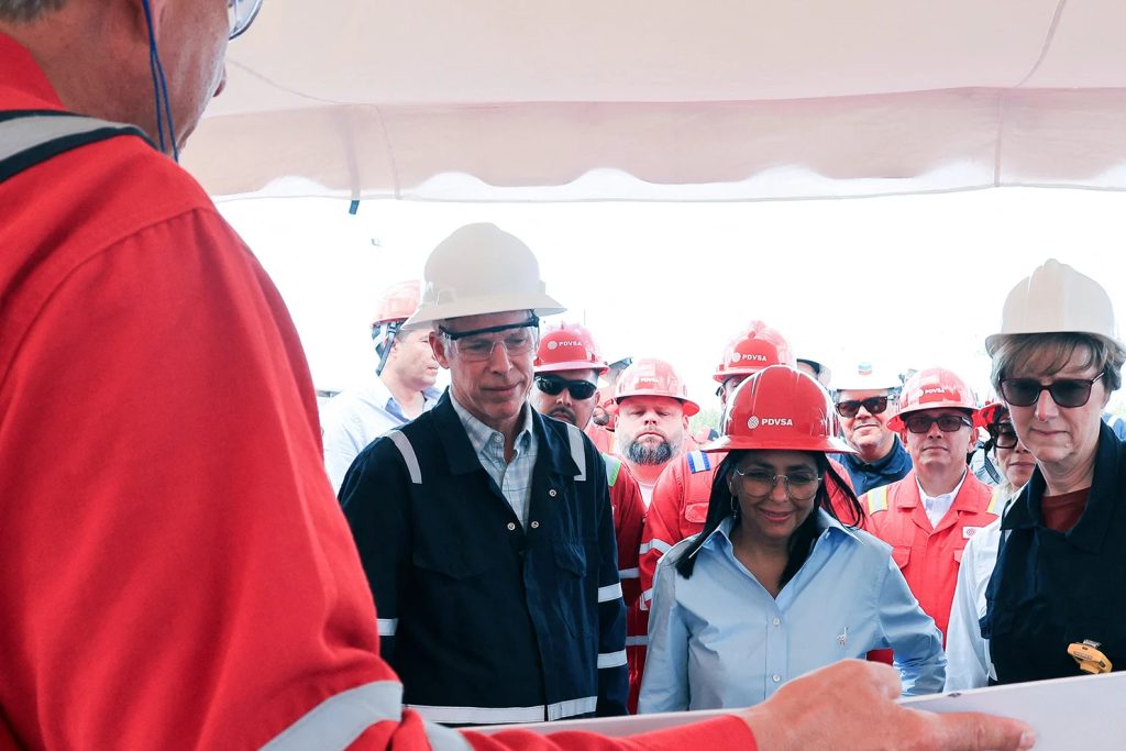 A group of people in industrial gear and hard hats attending a briefing in Venezuela.
