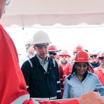 A group of people in industrial gear and hard hats attending a briefing in Venezuela.