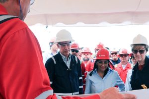A group of people in industrial gear and hard hats attending a briefing in Venezuela.