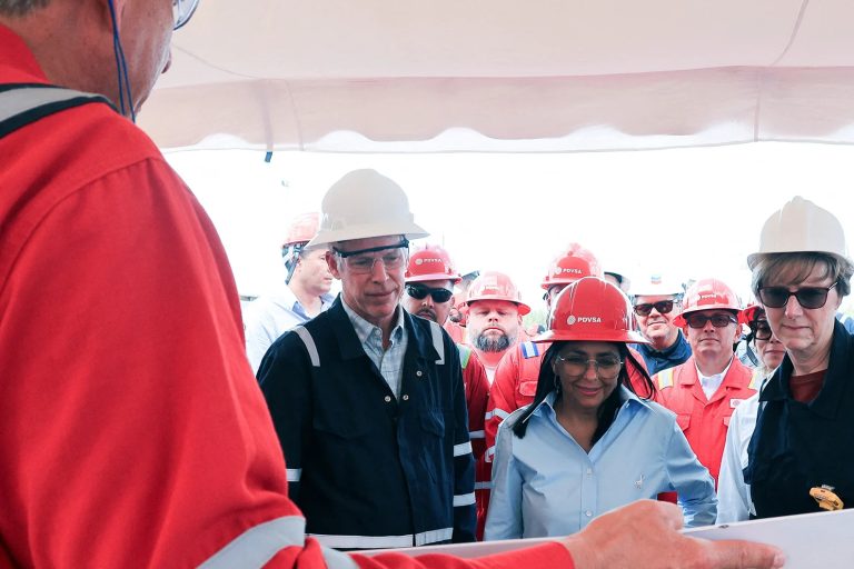 A group of people in industrial gear and hard hats attending a briefing in Venezuela.