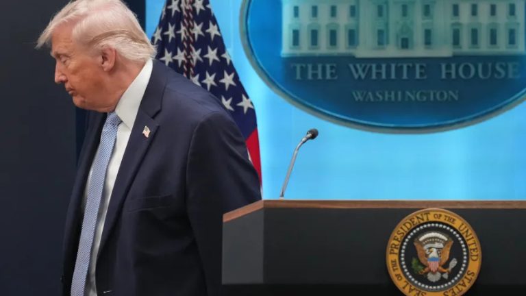 Former President Donald Trump walking away from a podium with the White House seal in the background.