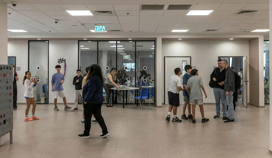 Diverse group of students talking and walking in a modern school hallway.