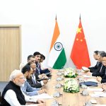 Indian and Chinese officials sit across from each other at a long conference table.