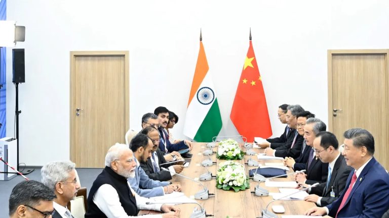 Indian and Chinese officials sit across from each other at a long conference table.