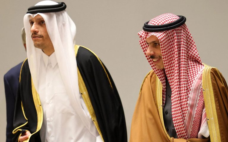 Officials in traditional Gulf Arab attire engaged in diplomatic discussions.