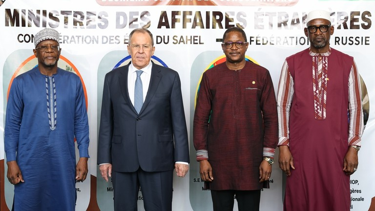 Four officials standing in a row in front of a banner during a diplomatic meeting between the Sahel and Russia.
