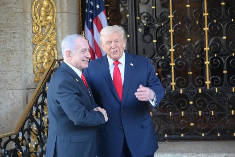 Donald Trump and Benjamin Netanyahu shaking hands outside a building.