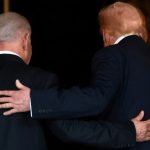 Back view of Benjamin Netanyahu and Donald Trump standing together with a hand on each other's shoulders.