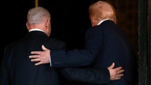 Back view of Benjamin Netanyahu and Donald Trump standing together with a hand on each other's shoulders.