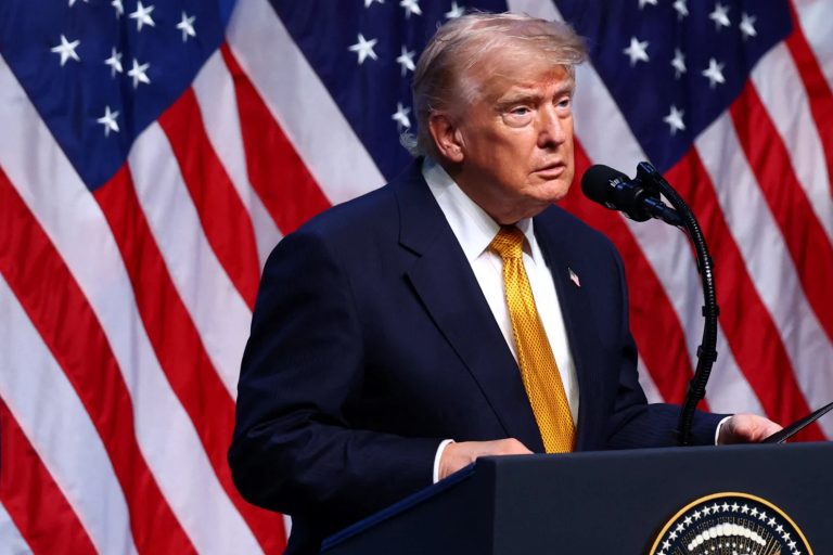 Former President Donald Trump speaking at a podium with American flags in the background.
