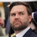 A close-up portrait of J.D. Vance looking pensively to the side.