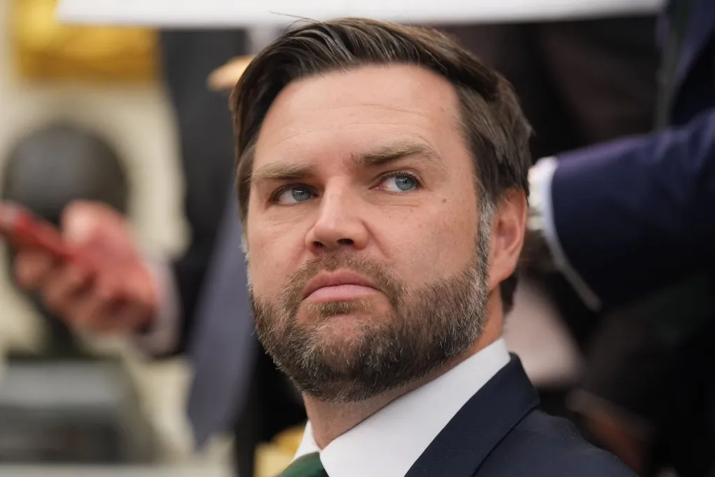 A close-up portrait of J.D. Vance looking pensively to the side.