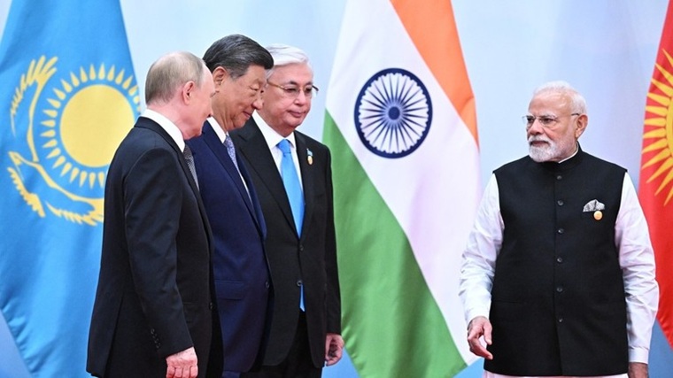 Narendra Modi greeting Vladimir Putin, Xi Jinping, and Kassym-Jomart Tokayev in front of national flags.