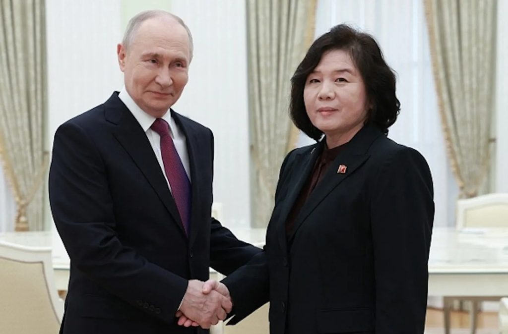 Vladimir Putin shaking hands with North Korean official Choe Son-hui during a formal meeting.
