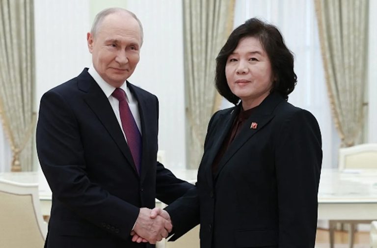 Vladimir Putin shaking hands with North Korean official Choe Son-hui during a formal meeting.