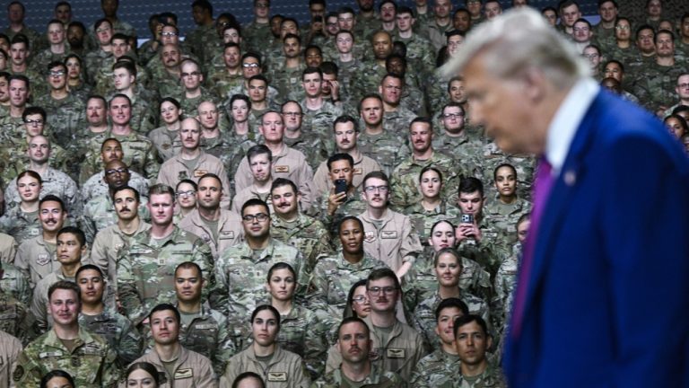 Donald Trump walking in front of a crowd of assembled US military service members