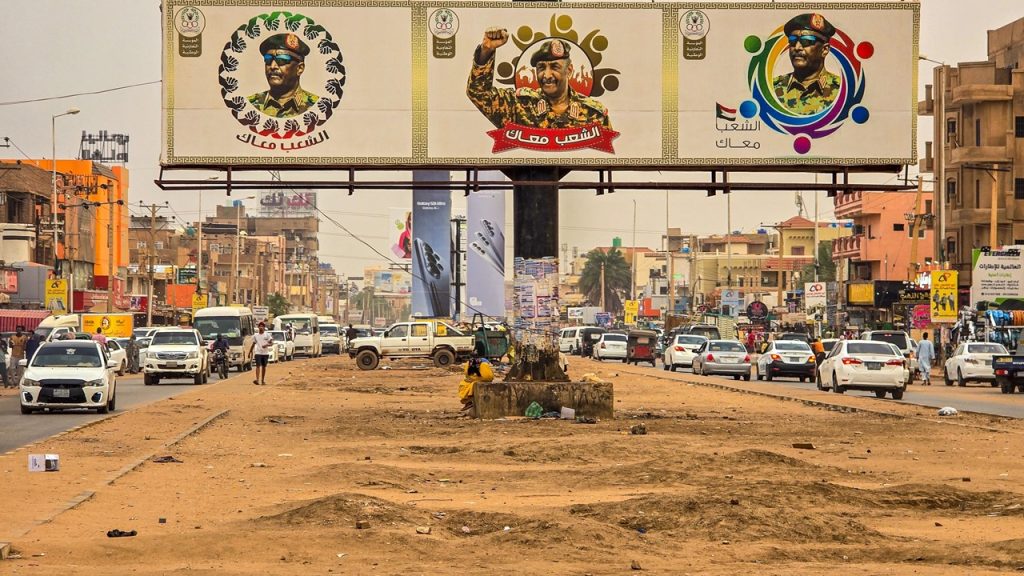 Dusty urban street in Sudan featuring a large billboard displaying military leaders alongside civilian cars.