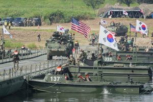 Joint military vehicles and amphibious assault boats participating in allied defense exercises.