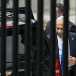 Israeli Prime Minister Benjamin Netanyahu walking behind black fence bars