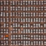 Top-down aerial view of thousands of rolled steel coils stored outdoors in an industrial yard.