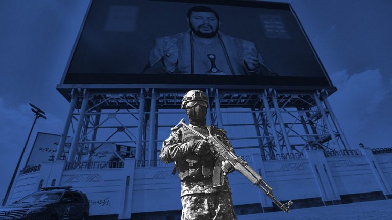 Armed military guard standing in tactical gear in front of a large outdoor screen displaying a political leader.