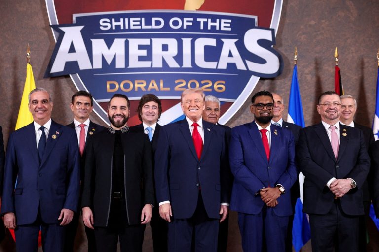 Donald Trump standing with Latin American and regional leaders under the Shield of the Americas banner