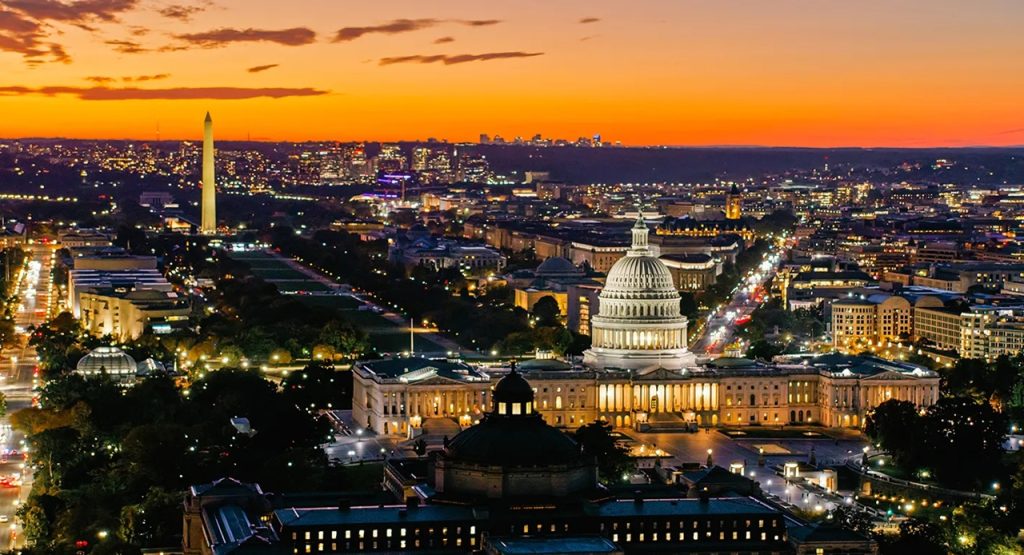 Panoramic aerial view of the US Capitol and Washington Monument illuminated at sunset in Washington, D.C.