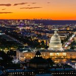 Panoramic aerial view of the US Capitol and Washington Monument illuminated at sunset in Washington, D.C.
