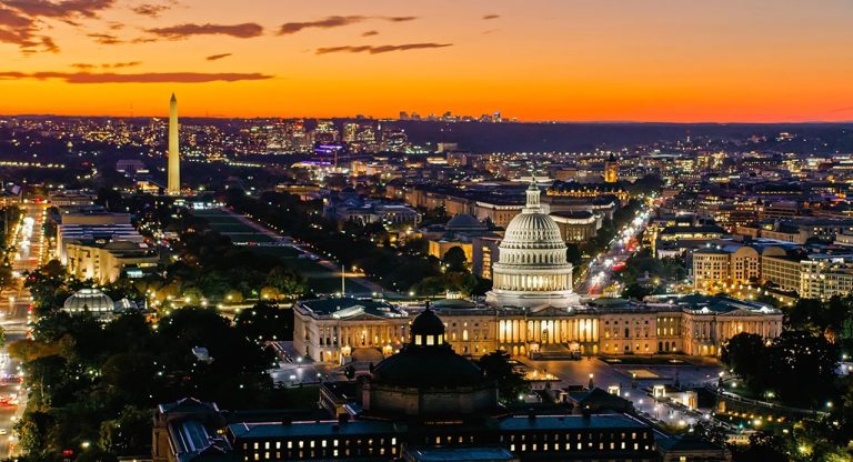 Panoramic aerial view of the US Capitol and Washington Monument illuminated at sunset in Washington, D.C.