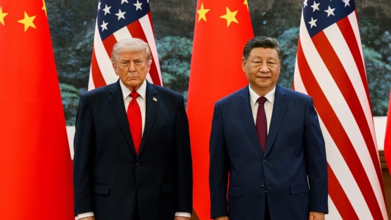 Donald Trump and Xi Jinping standing side-by-side in front of American and Chinese flags.