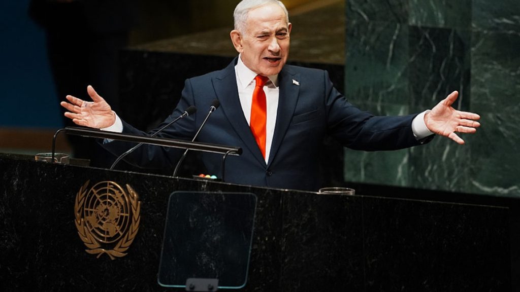 Israeli Prime Minister Benjamin Netanyahu gesturing with both hands while speaking at the United Nations General Assembly lectern.