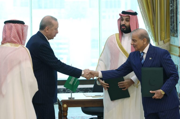 Turkish President Recep Tayyip Erdoğan shaking hands with Pakistani Prime Minister Shehbaz Sharif alongside Saudi Crown Prince Mohammed bin Salman.
