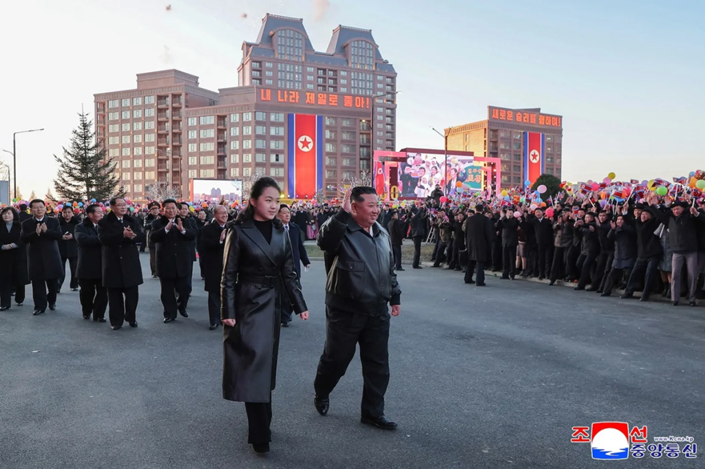 Kim Jong Un and his daughter walking through a crowd during a public event in North Korea.