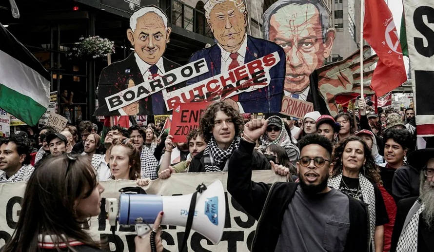 Protesters marching with Palestinian flags, a megaphone, and oversized caricature cutouts depicting political leaders.