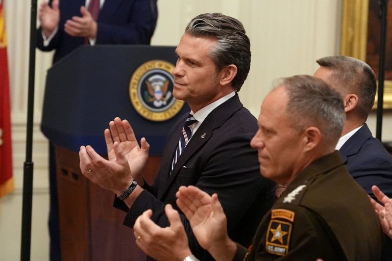 Pete Hegseth clapping alongside military officials during a formal event.