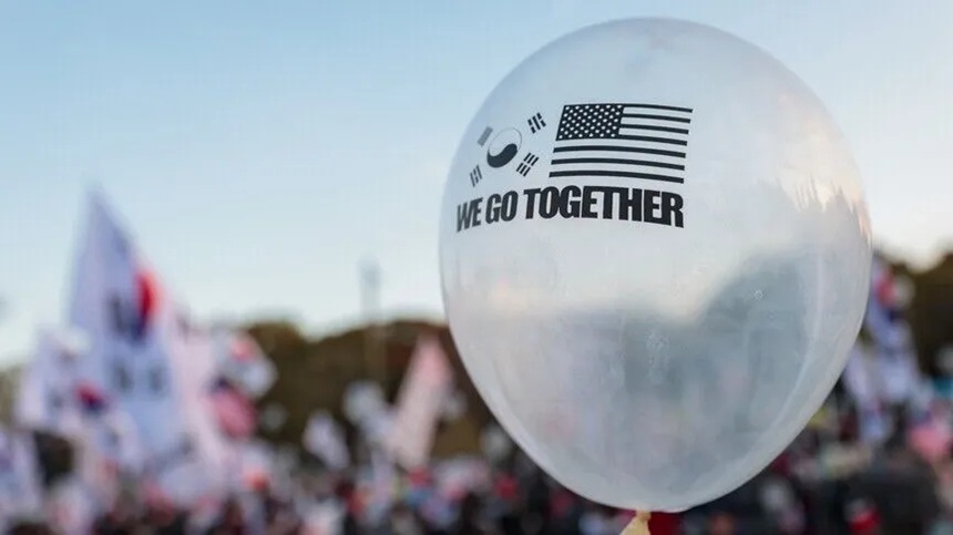 A white balloon printed with the US and South Korean flags and the phrase WE GO TOGETHER.