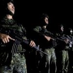 Taiwanese military soldiers standing in formation holding rifles during a nighttime exercise.