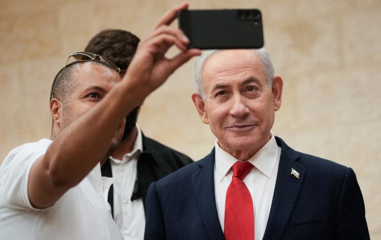 Israeli Prime Minister Benjamin Netanyahu posing for a selfie taken by a bystander.