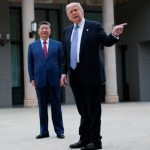 Donald Trump gesturing while standing alongside Xi Jinping outdoors.