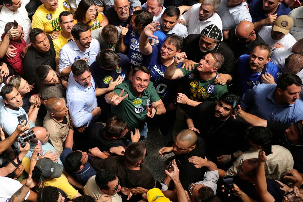 Overhead view of a political candidate surrounded by an energetic crowd holding up campaign hand signs