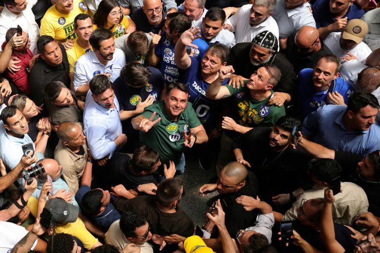 Overhead view of a political candidate surrounded by an energetic crowd holding up campaign hand signs