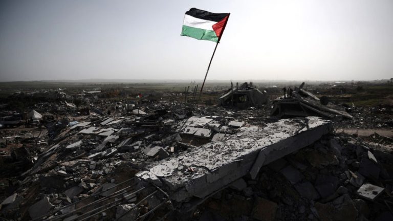 Palestinian flag planted in concrete debris amid widespread structural destruction in Gaza