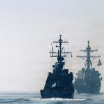 Israeli and American naval destroyers sailing in line on calm ocean waters