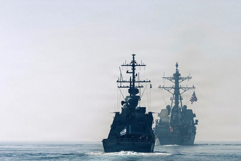 Israeli and American naval destroyers sailing in line on calm ocean waters