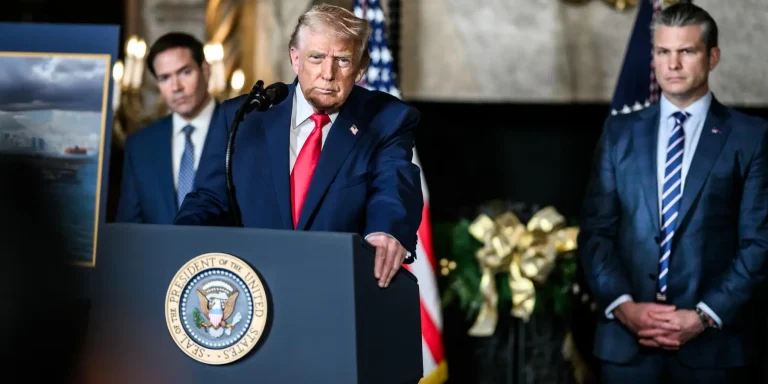 Donald Trump speaking at a presidential podium with Marco Rubio and Pete Hegseth standing behind him