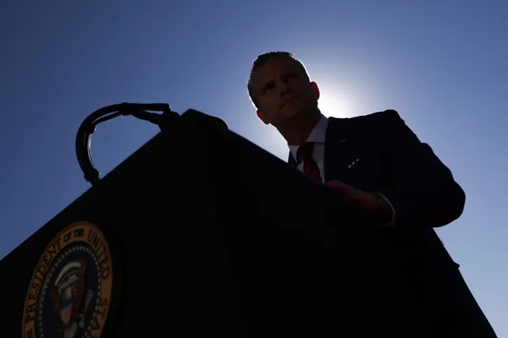 Silhouette of an official speaking from behind a podium bearing the Seal of the President of the United States