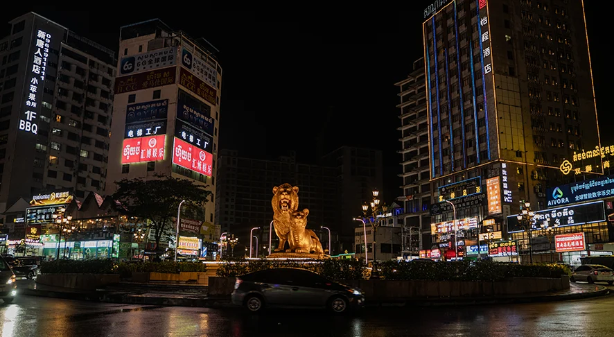 Sihanoukville Golden Lions roundabout at night surrounded by illuminated casinos and high-rise commercial buildings