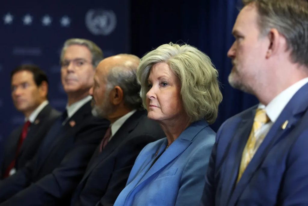 White House Chief of Staff Susie Wiles and senior Trump administration officials seated in a row with serious expressions.