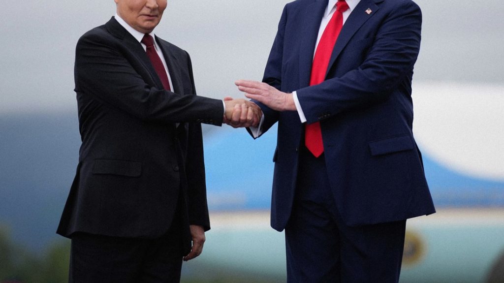 Vladimir Putin in a dark suit and red tie shaking hands with Donald Trump in a navy suit and bright red tie in front of an airplane.