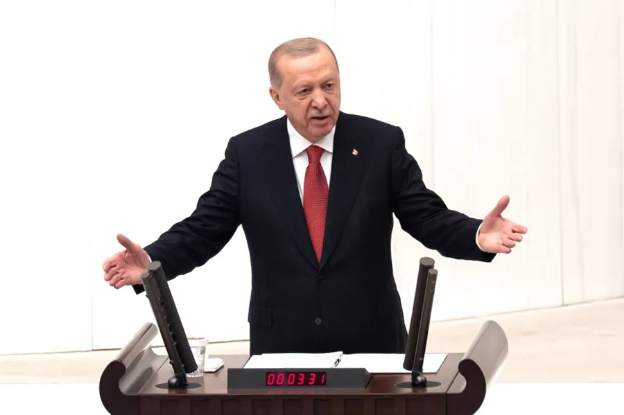 Turkish President Recep Tayyip Erdoğan gesturing from behind a rostrum during a speech